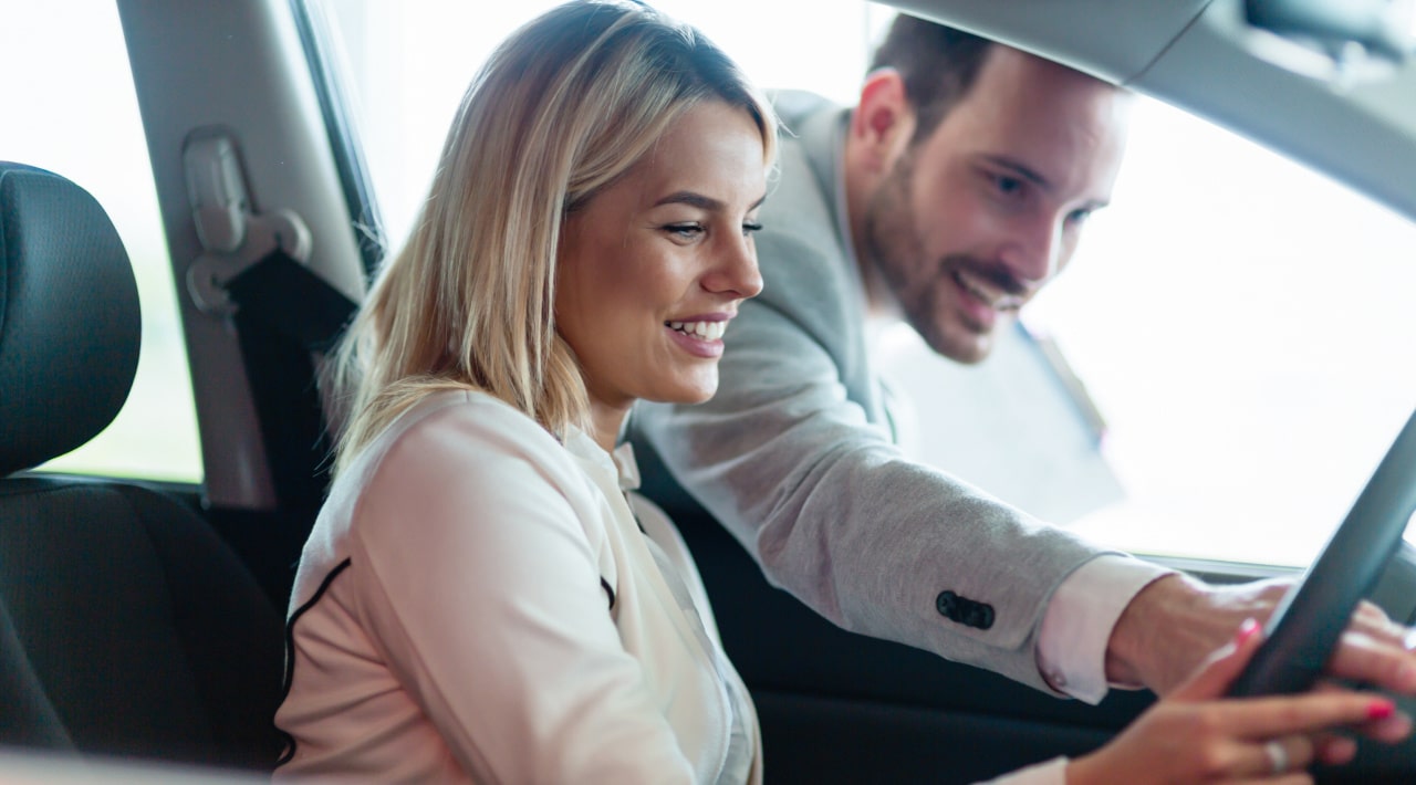 Couple souriant dans une voiture en leasing